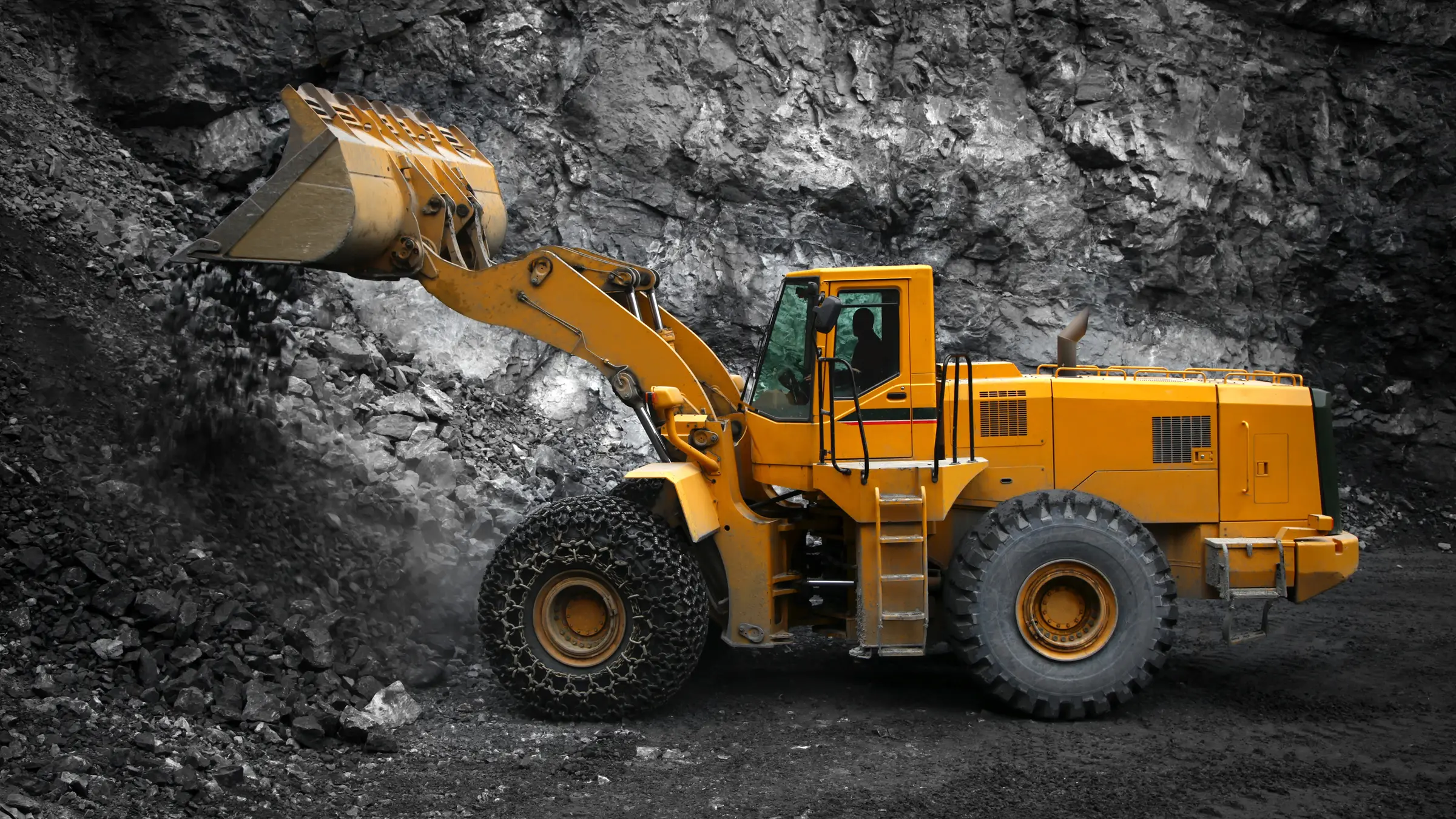 A wheel loader working the rock face of a mine