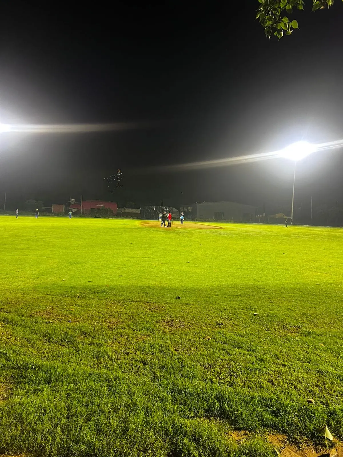 A One7 Sports cricket ground under floodlights at night